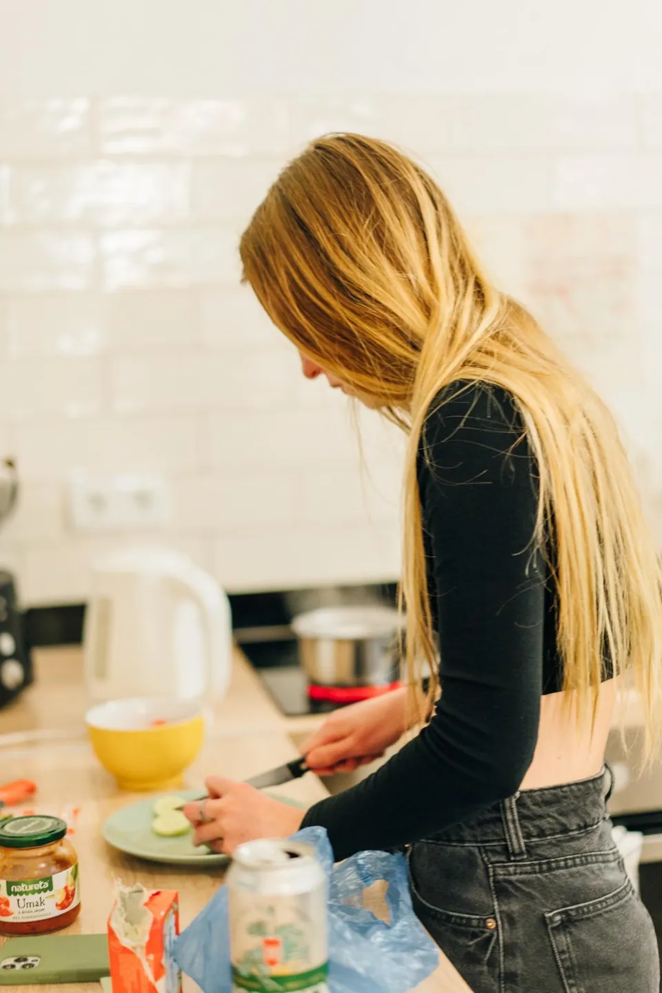 A guest cutting fruit in the hostel kitchen